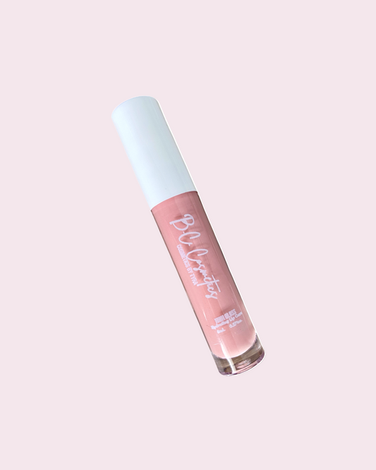 A tube of lip gloss with a pink nude shade, presented with a cap and the brand name 'PLUSH' visible on the product.